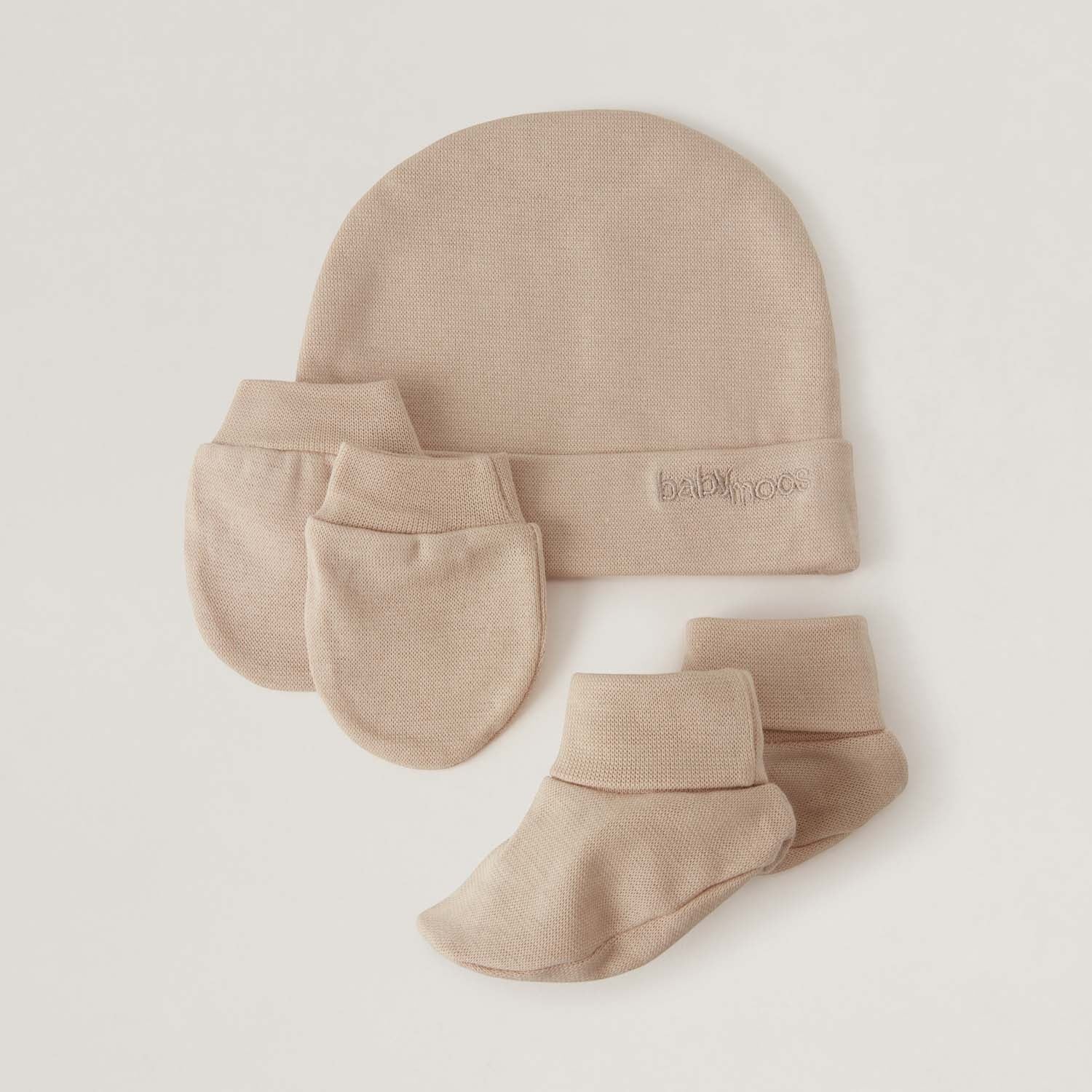 BabyMocs beige newborn set med mössa, vantar och sockor i mjuk bomull. Broderad logotyp.